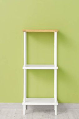 Empty white shelving unit near green wall