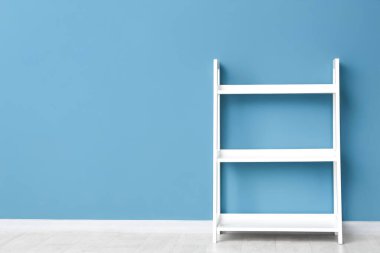Mavi duvarın yanında boş beyaz raf ünitesi