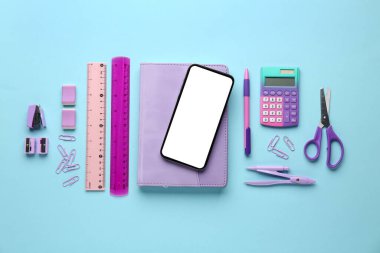 Mavi arka planda cep telefonu olan okul kırtasiyesi