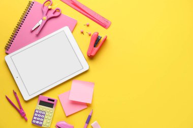 Sarı arka planda tablet bilgisayarlı okul kırtasiyesi
