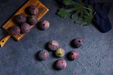 Koyu arkaplanda taze incir bulunan ahşap tahta tahta.