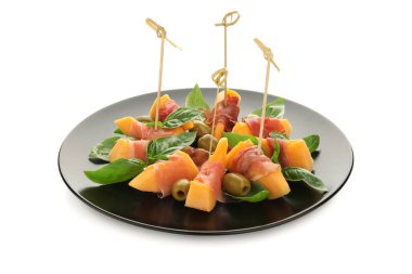 Lezzetli prosciutto, zeytin ve fesleğen yapraklı taze kavun parçaları beyaz arka planda