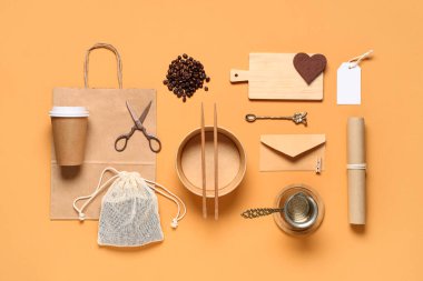 Kahve seti, kase, yemek çubuğu ve turuncu arka planda teslimat kağıdı içeren kompozisyon