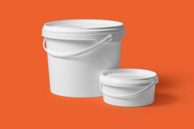 Turuncu arka planda beyaz plastik boya kovaları