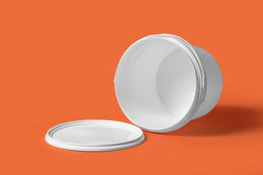 Turuncu arka planda plastik boya kovası