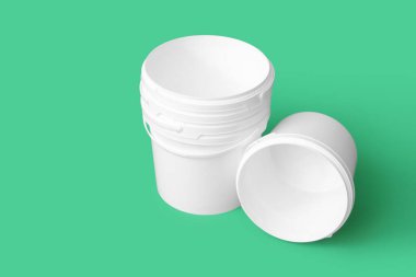 Yeşil arka planda plastik boya kovaları