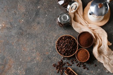 Geyser kahve makinesi, gri arka planda fasulye ve pudra.