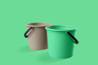 Yeşil arkaplanda plastik kovalar