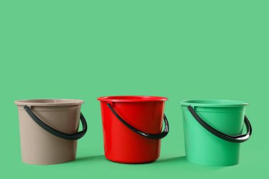 Yeşil arkaplanda plastik kovalar