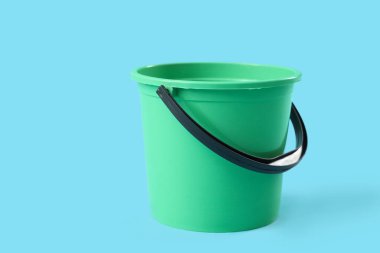 Mavi arkaplanda yeşil plastik kova