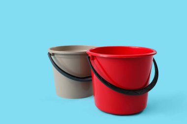 Mavi arkaplanda plastik kovalar