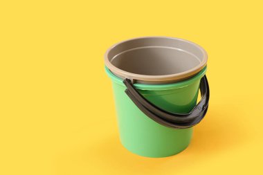 Sarı arkaplanda plastik kovalar