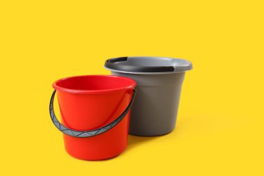 Sarı arkaplanda plastik kovalar