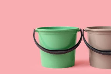 Pembe arka planda plastik kovalar