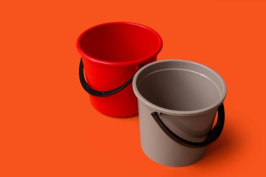 Turuncu arka planda plastik kovalar