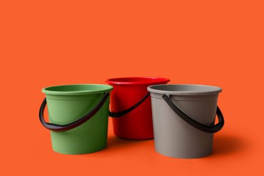 Turuncu arka planda plastik kovalar