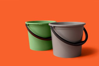 Turuncu arka planda plastik kovalar