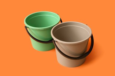 Turuncu arka planda plastik kovalar