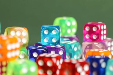 Yeşil arkaplanda renkli oyun zarları, yakın plan