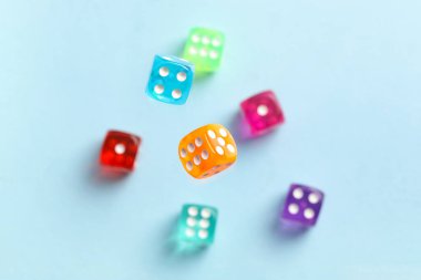 Mavi arkaplanda uçan renkli oyun zarları