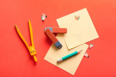 Turuncu arka planda çıkartma, pusula ve kalem olan silgi