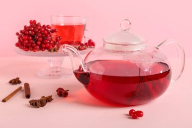 Bir bardak sıcak viburnum çayı tarçınlı ve böğürtlenli pembe arka plan