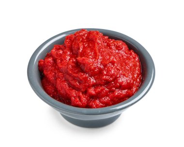 Beyaz arka planda bir kase lezzetli domates ezmesi.