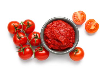 Beyaz arka planda bir kase lezzetli domates ezmesi ve sebze.