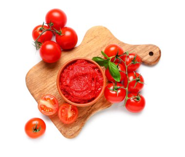 Beyaz arka planda fesleğen yapraklı ve sebzeli bir kase lezzetli domates ezmesi.