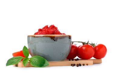 Fesleğen yapraklı ve beyaz arka planda biberli bir kase lezzetli domates ezmesi.