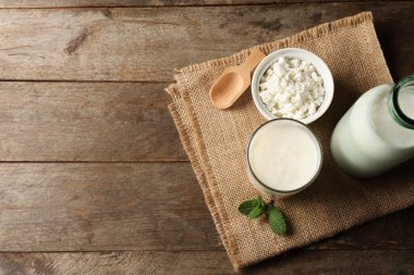 Bir bardak taze kefir naneli ve ahşap arka planda bir kase süzme peynir.