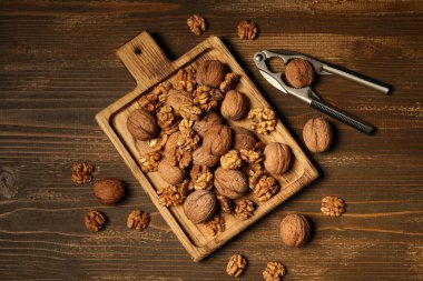 Ahşap arka planda kabuklu ceviz ve fındık kıracağı olan tahta.