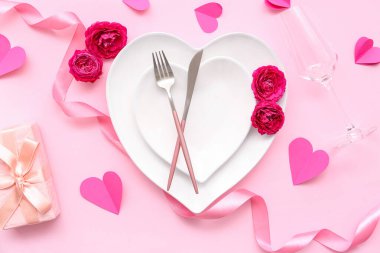 Sevgililer Günü 'nde hediye paketi, gül çiçekleri ve pembe arka planda kağıt kalplerle masa ayarı.