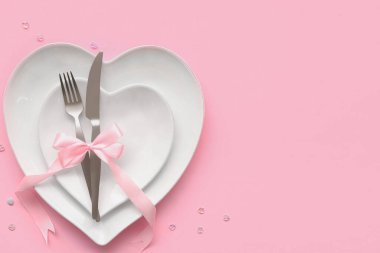 Sevgililer Günü için güzel bir masa. Pembe arka planda boncuklar ve kurdeleler var.