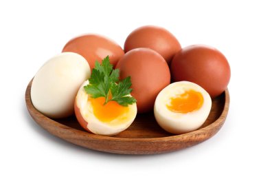 Yumuşak yumurta ve beyaz arka planda maydanozlu ahşap tabak.