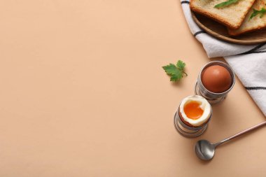 Kaynamış yumurta ve bej arka planda dilimleri olan tutucular.