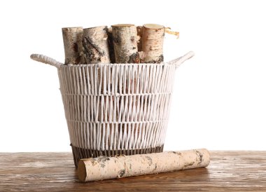 Tahta sepetin üzerinde ağaç kütükleri beyaz arka planda.