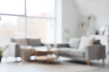 Gri kanepeler ve geniş pencereli bulanık oturma odası manzarası