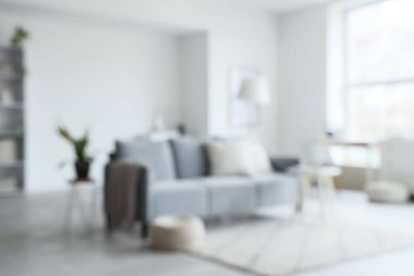 Bulanık oturma odası, gri kanepe, lamba ve masa.