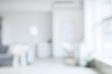 Bulanık oturma odası, gri kanepe, lamba ve masa.