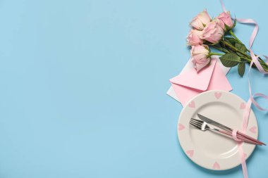 Sevgililer Günü için güzel bir masa. Zarflı ve mavi arka planda gül çiçekleri.