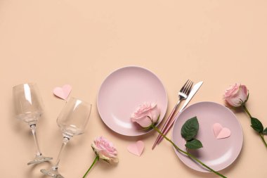 Sevgililer Günü için güzel bir masa. Kağıt kalpler ve bej arka planda gül çiçekleri.