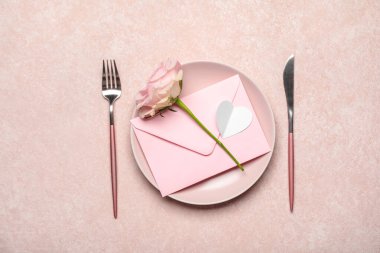 Sevgililer Günü için güzel bir masa. Zarflı ve pembe arkaplanlı gül çiçekli.