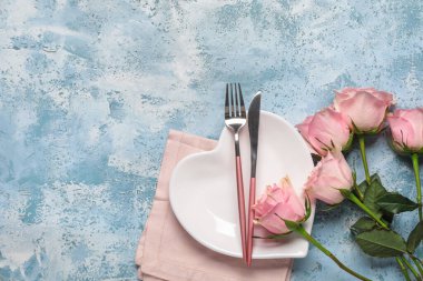 Sevgililer Günü için güzel bir masa ve mavi grunge arka planda pembe gül çiçekleri.