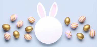 Tavşan kulaklı boş kart ve açık arkaplanda Paskalya yumurtaları.