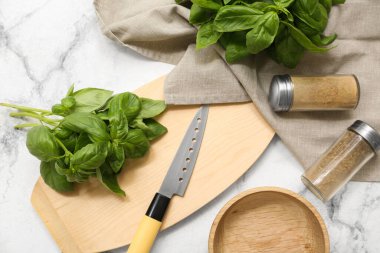 Taze yeşil fesleğen yapraklı ahşap tahta ve beyaz arka planda baharatlar.