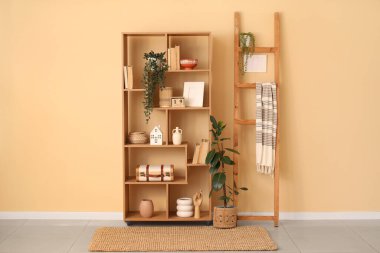 Kitaplı raf ünitesi, oturma odasındaki bej duvarın yanında farklı dekorasyon ve merdiven.