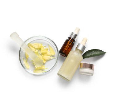 Beyaz arka planda yaprakları ve yaprakları olan doğal kozmetik ürünleri