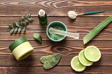Kabuklu havan, guasha ve ahşap arka planda doğal kozmetik malzemeleri.