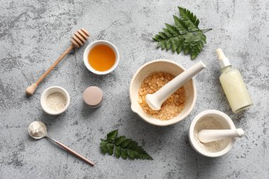 Arkaplanda doğal kozmetik malzemeleri ve tokmağı olan havan topu.